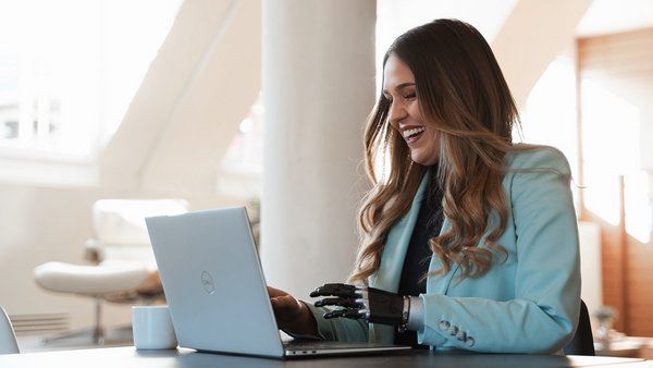 Laughing woman networking digitally on her laptop