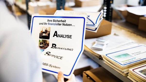 Person hält einen Ausdruck der ABS-Beratungsstrategie in den Händen.