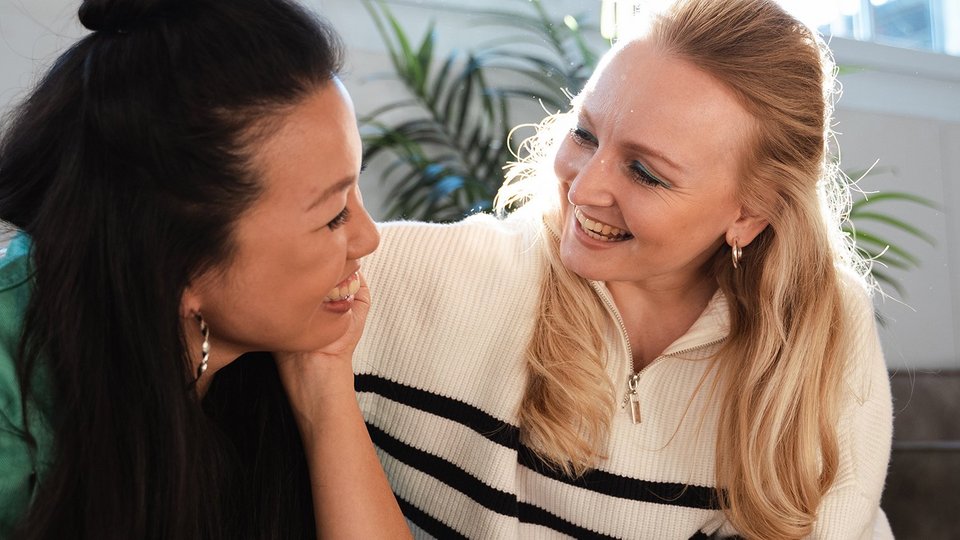 Our social focus Two women look at each other laughing