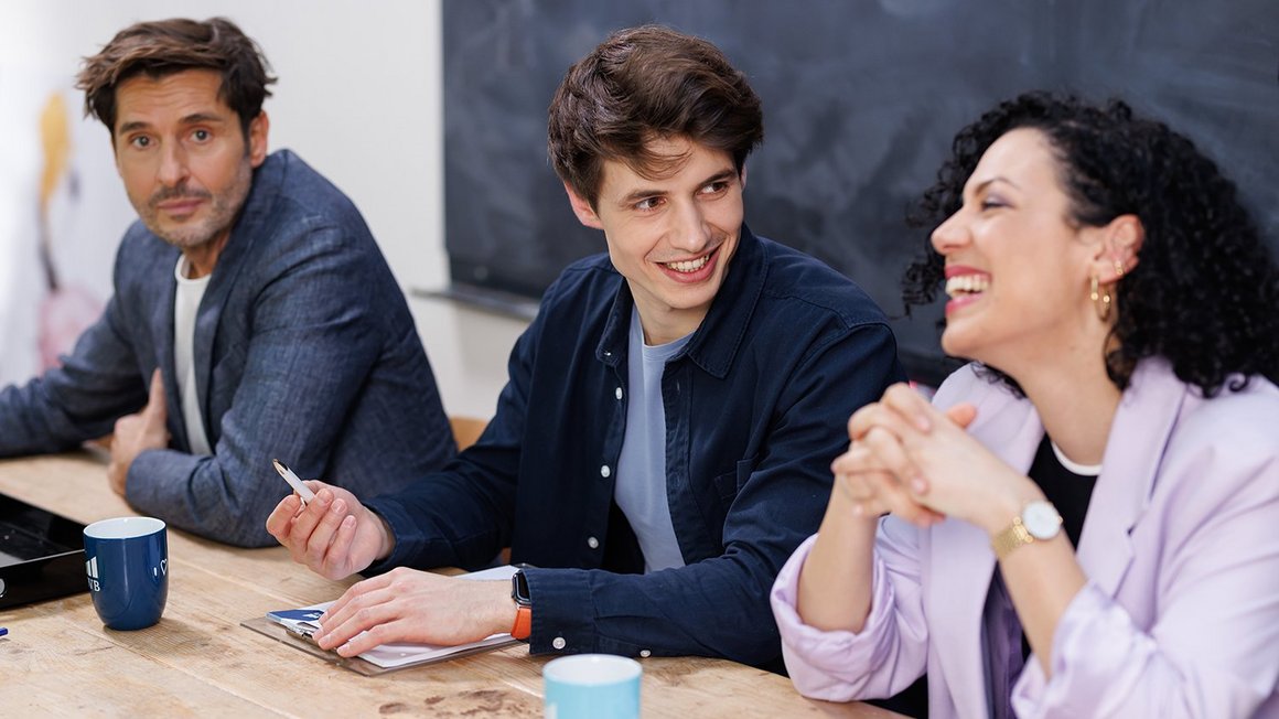 How to motivate your team: 9 tips Team sitting at the table and laughing