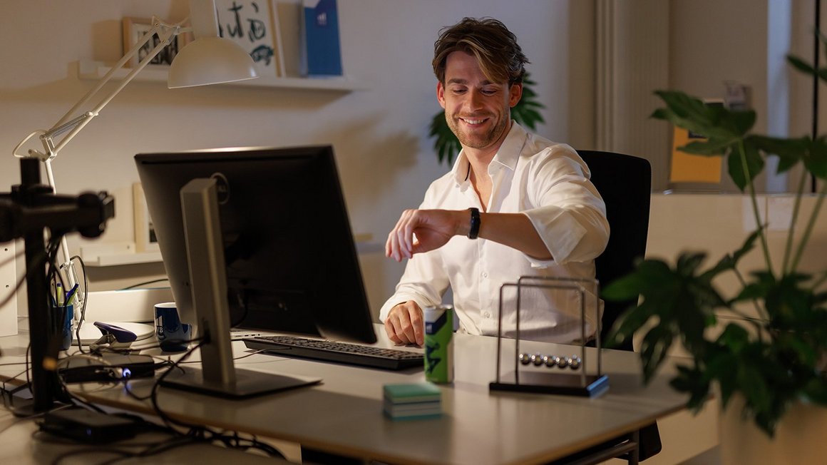 Die richtige Abendroutine Mann am Schreibtisch schaut auf die Uhr und startet in die Abendroutine