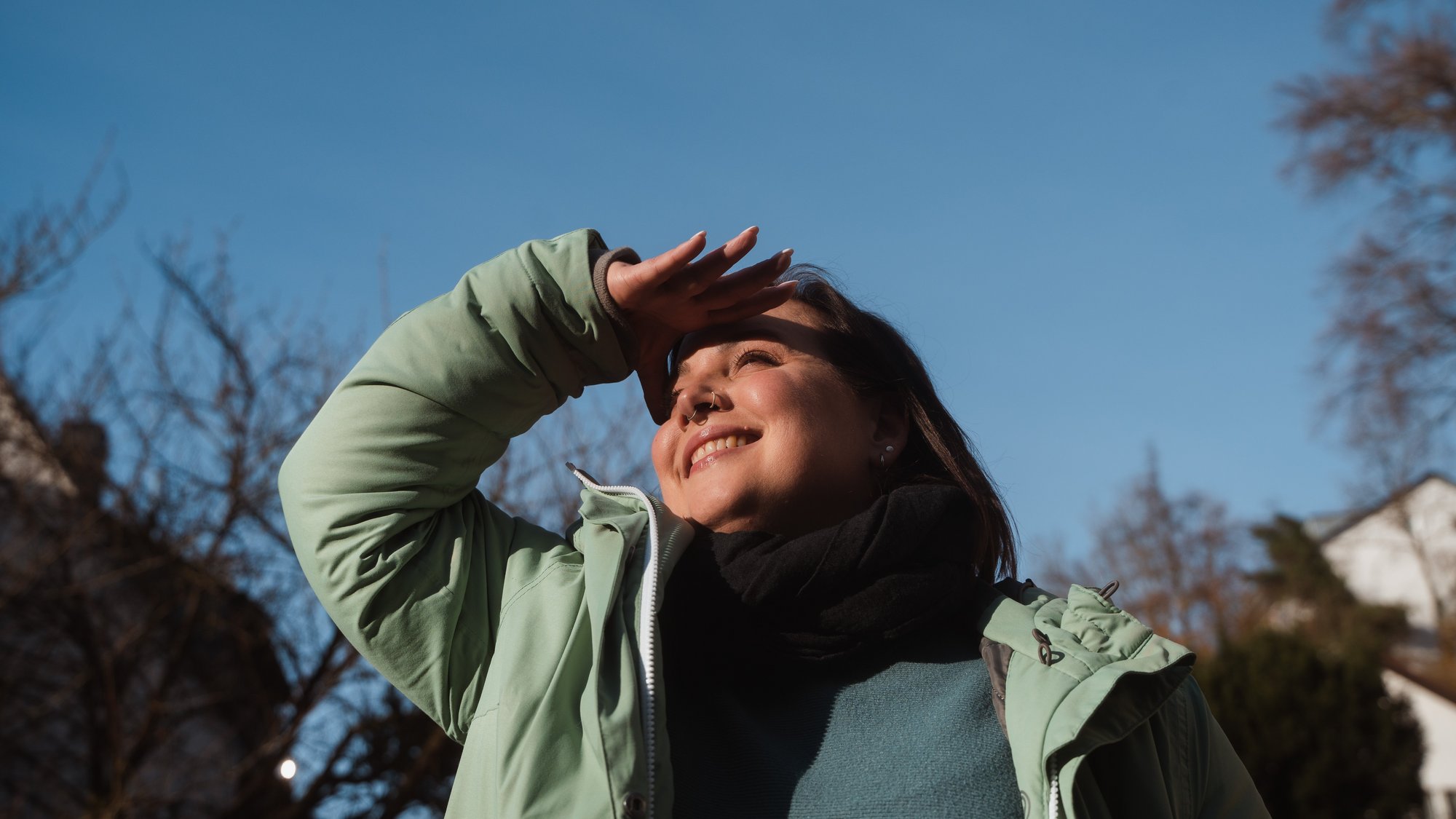 Nachhaltigkeit ist Teil unserer Verantwortung Junge Frau steht draußen und schaut zuversichtlich in die Ferne.