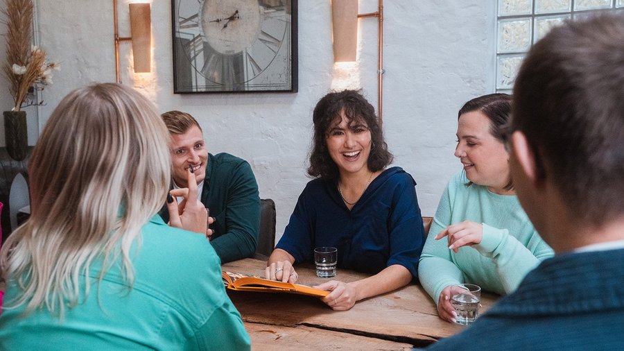 Work Trends: Die Top 5 Trends der Arbeitswelt 2025 Team sitzt lachend im Meeting zusammen