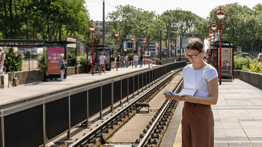 Nathalie from OVB writes in her journal at the tram station during her morning routine