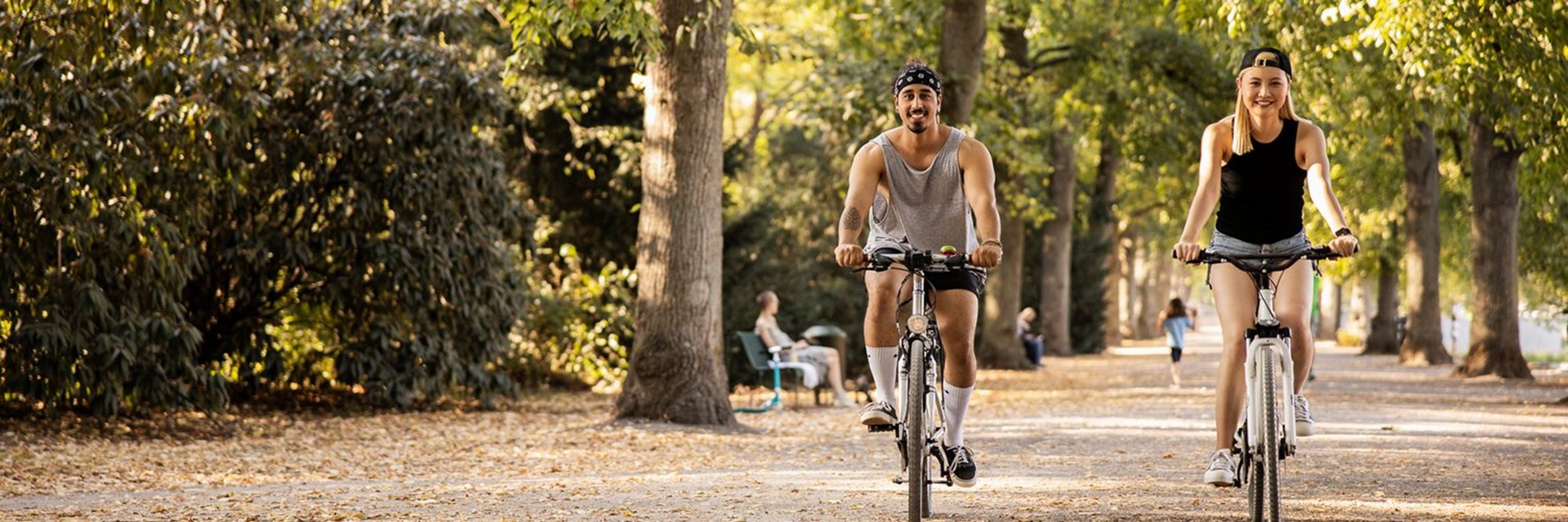 Zwei junge Leute fahren Rad im Park