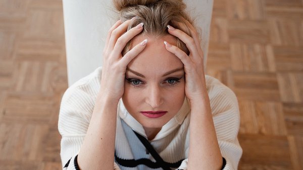 Signs that you need a digital detox  Stressed woman leans her head on her hands