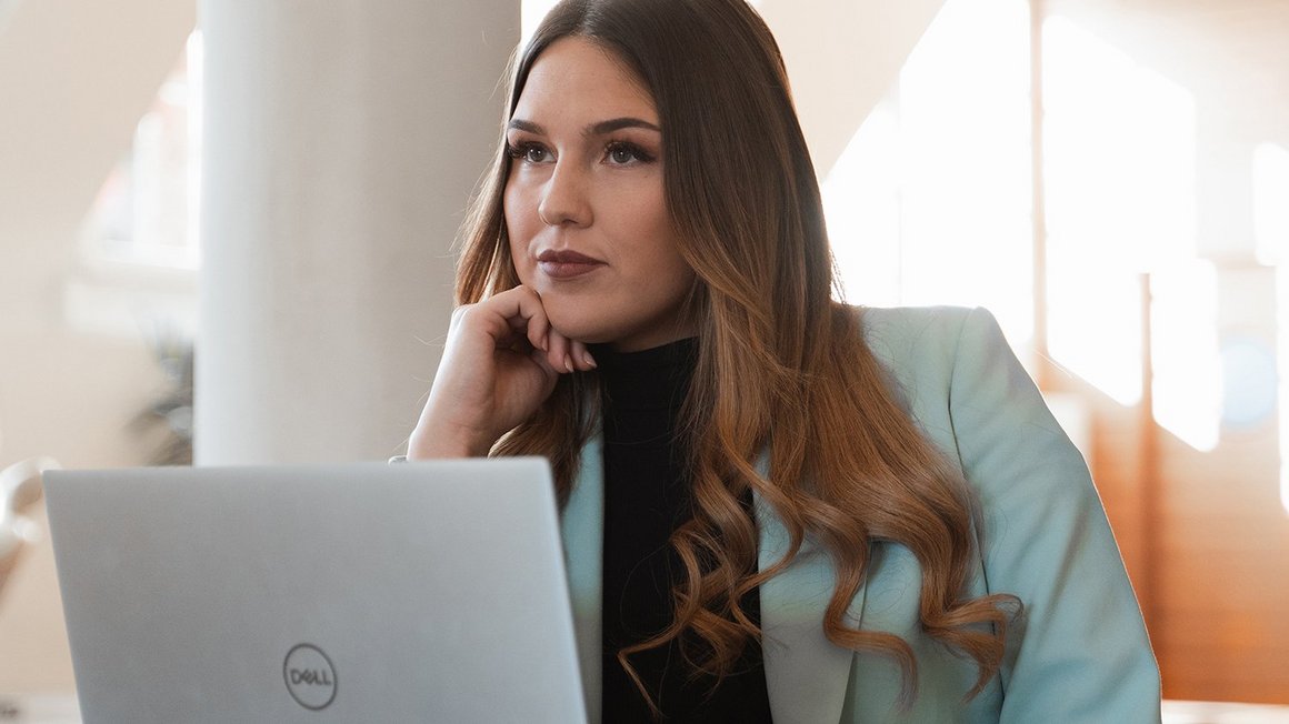 10 tips to increase your own productivity Woman sits at her laptop thinking