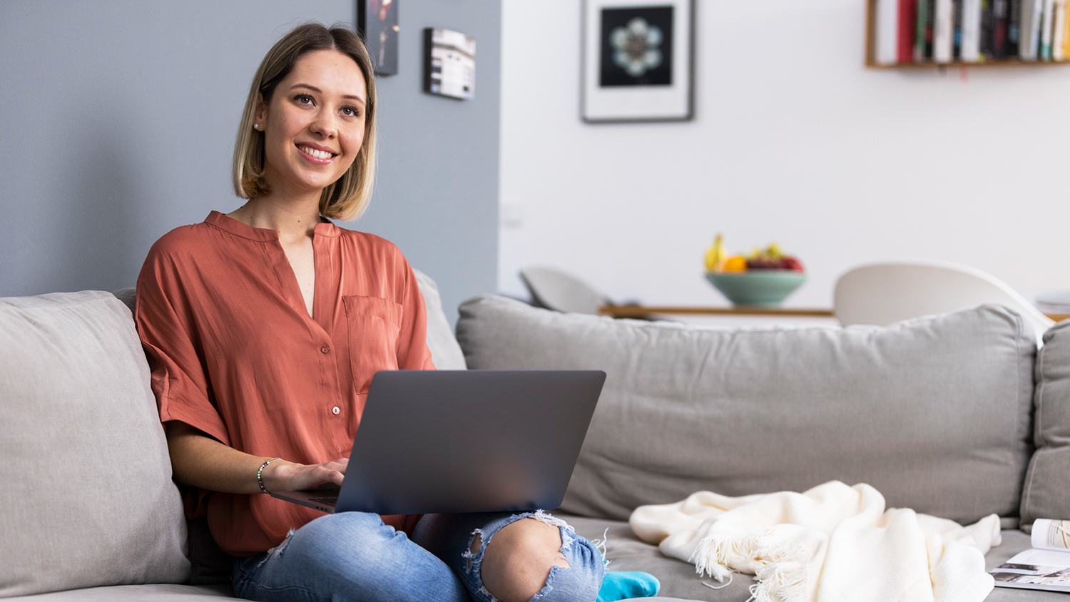 Woman with laptop on the couch – Work-life integration Woman with laptop on the couch – Work-life integration