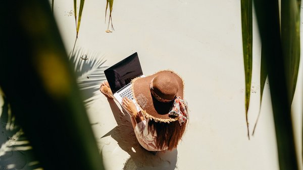 Woman working on the beach - remote work abroad Woman working on the beach - remote work abroad
